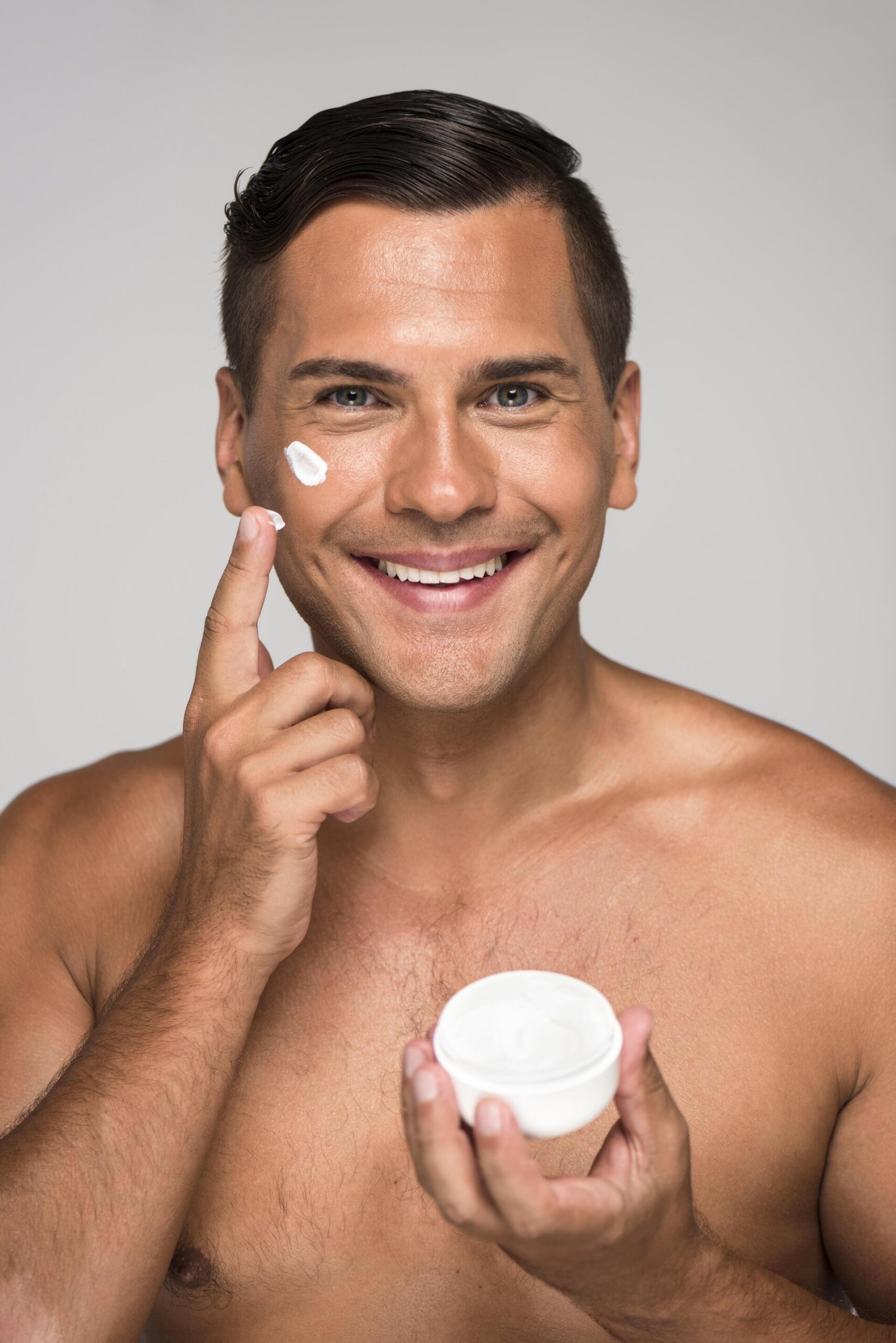primer plano sonriente hombre tenencia crema facial